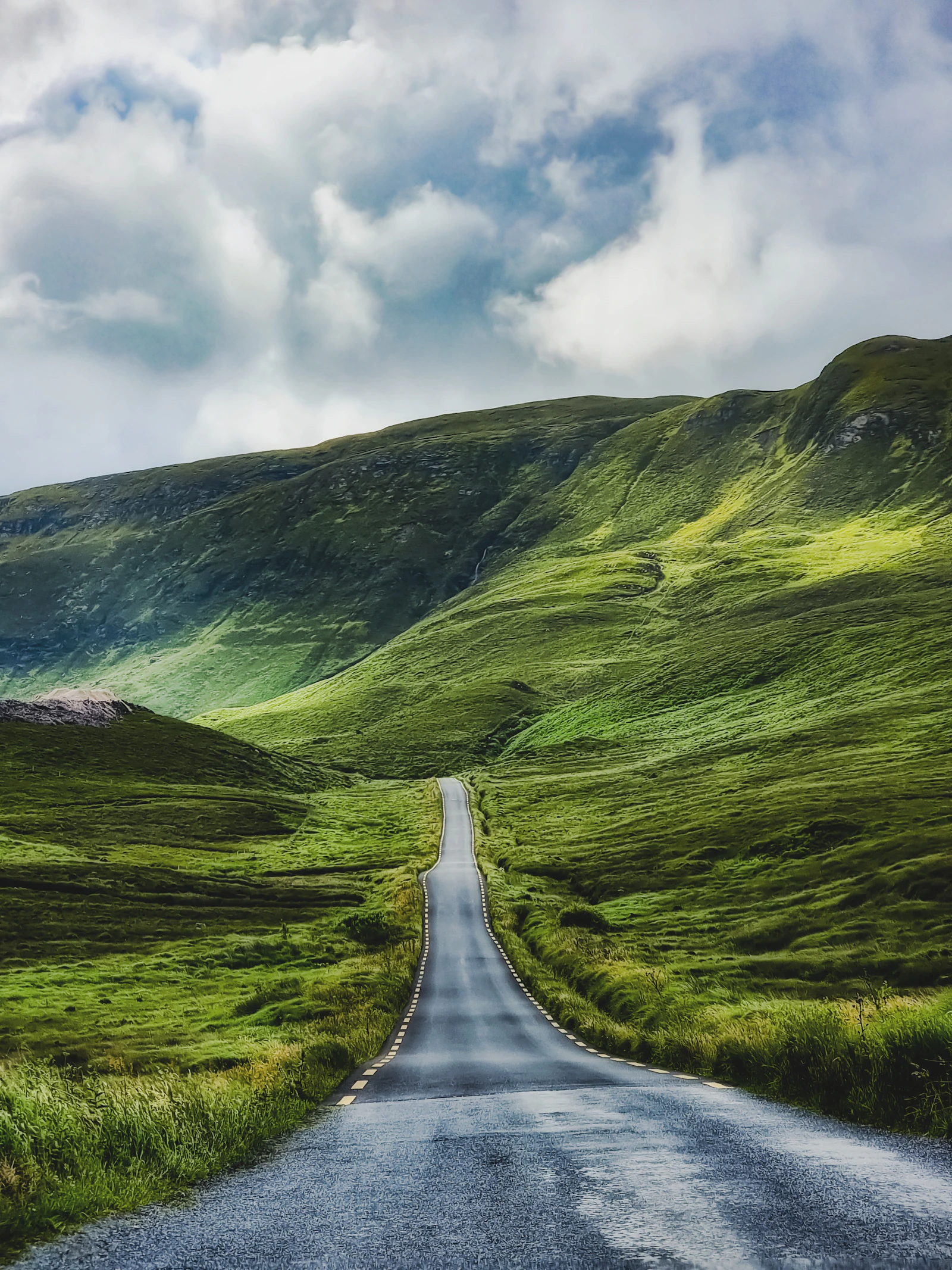 A winding road through the green hills of Glenshee, Scotland.