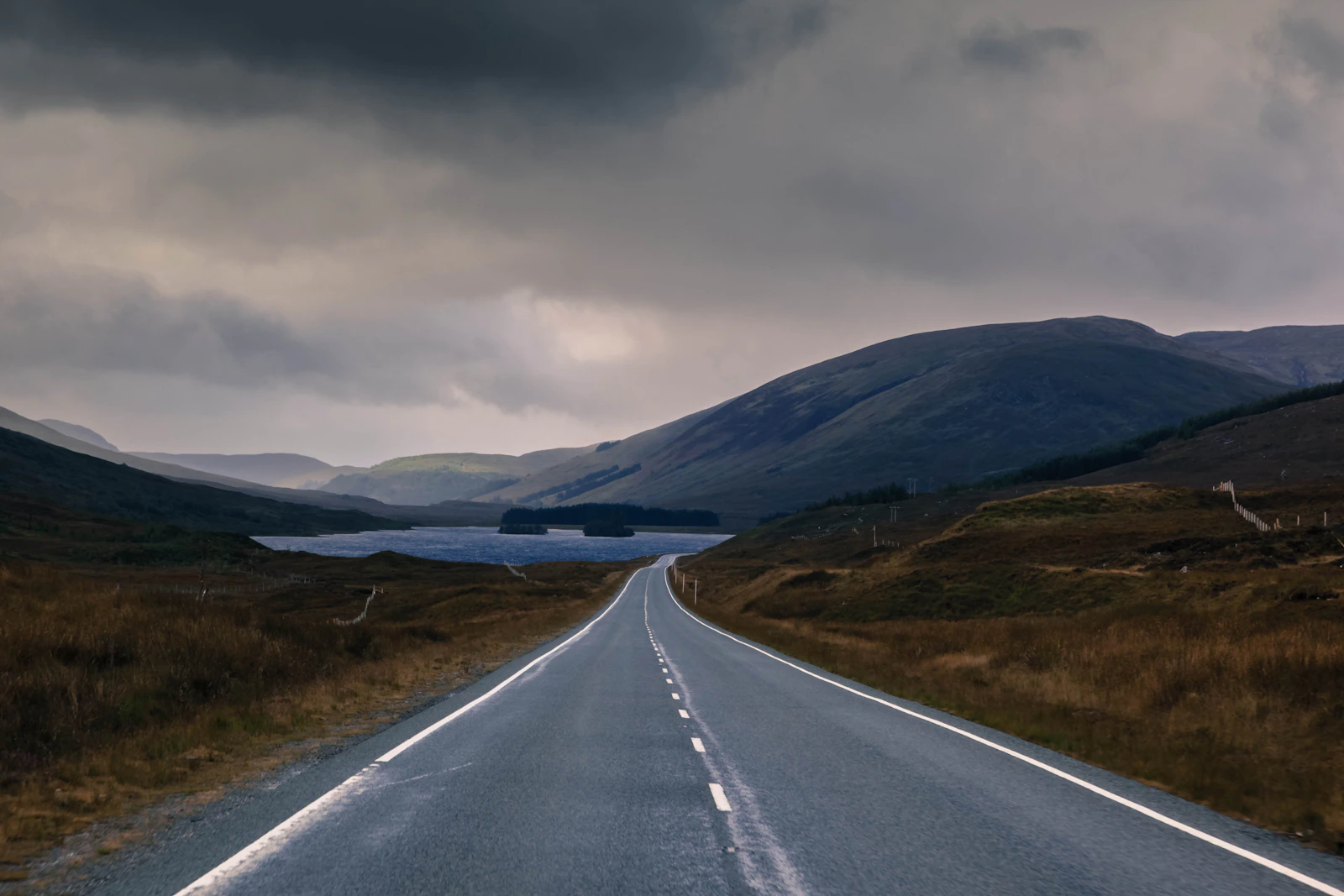 A quiet road beneath dramatic clouds on the Isle of Skye, Scotland.